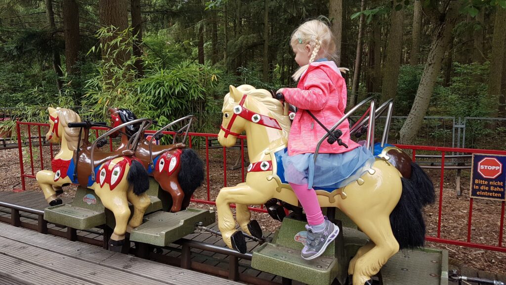 Familie im Magic Park Verden zwischen Fahrgeschäften und Märchenwald